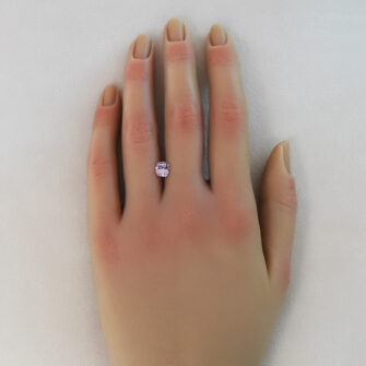 A pink spinel shown on a lady's hand.