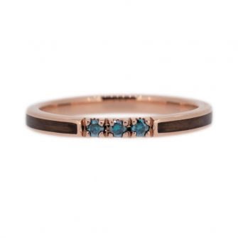 A wedding ring that has been inlaid with walnut wood and colored diamonds