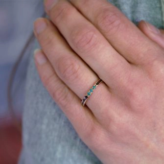 A women's wooden wedding ring shown on a ring finger