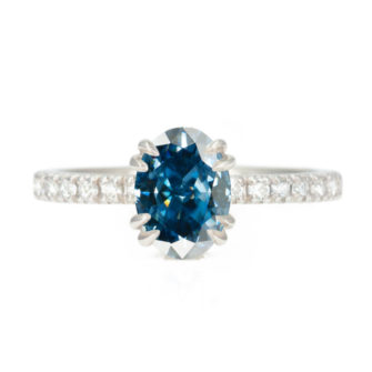 An image of a blue moissanite engagement ring paired with a lab-grown diamond eternity band.