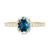 An image of a blue oval moissanite engagement ring in 14k yellow gold.