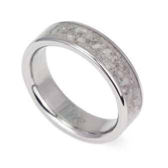 A professionally crafted titanium ring displaying an intricate beach sand inlay.