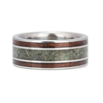 Close-up view of the intricate grain of koa wood and emerald inlay in this wood wedding band.