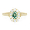 An image of an oval cut engagement ring with a green moissanite center stone.