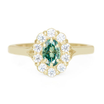 An image of an oval cut engagement ring with a green moissanite center stone.