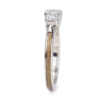 A unique engagement ring showcasing three sparkling diamonds and a warm cedar wood accent.