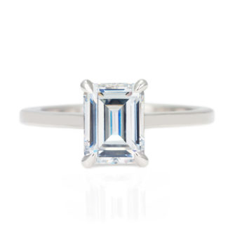 An image of an emerald cut solitaire moissanite engagement ring.