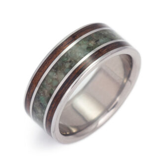 Image of our dark koa wood wedding band with emerald, symbolizing a unique bond and commitment.