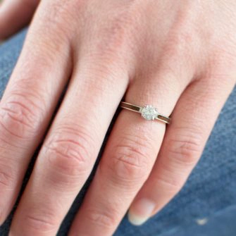 An image of a low profile diamond engagement ring shown on a lady's left ring finger