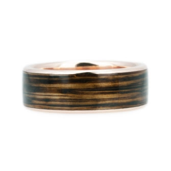 A picture of a whiskey barrel wood ring in rose gold.