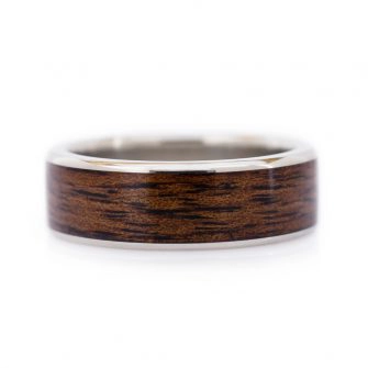 An image of a 14k white gold ring with koa wood inlaid into it.