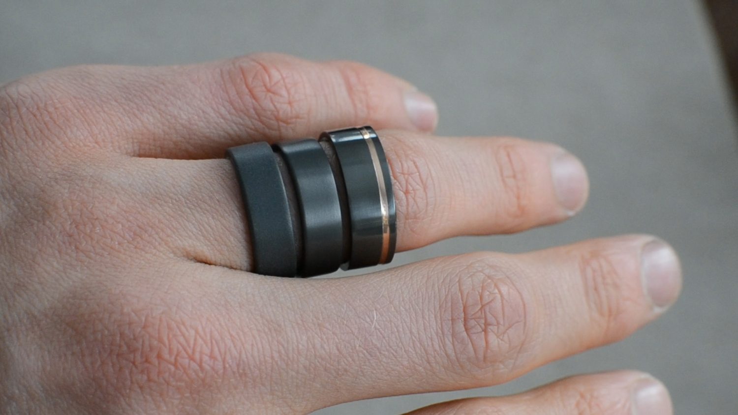 Various types of ring finishes for men's rings. The image features three black zirconium rings, each finished differently.