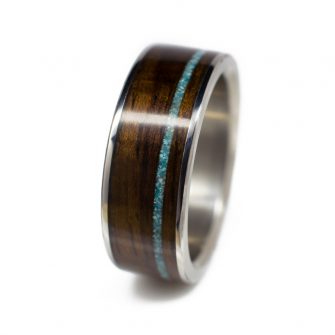 A men's wood wedding band made from titanium, ironwood, and turquoise.