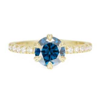 An image of a yellow gold engagement ring set with a blue moissanite.