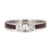 A front-on view of a modern three-stone engagement ring featuring three baguette-cut diamonds set in 14k white gold with a distinctive wood inlay band.