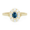 A picture of a yellow gold engagement ring with a blue moissanite center stone.