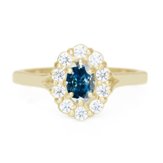 A picture of a yellow gold engagement ring with a blue moissanite center stone.