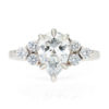 A picture of a pear cut moissanite engagement ring with a lab-grown diamond cluster.