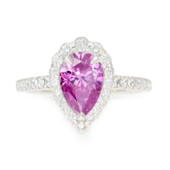 An image of a pink pear cut moissanite engagement ring with diamond accent stones.