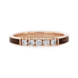 An image of a 14k rose gold wedding ring inlaid with redwood