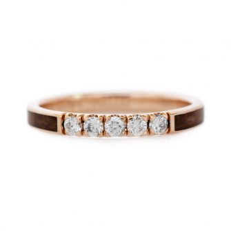 An image of a 14k rose gold wedding ring inlaid with redwood