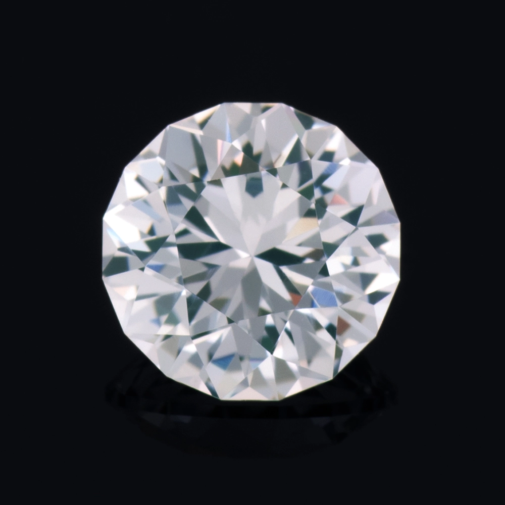 An image of a lab-created round white sapphire, hand cut by us here in the studio.
