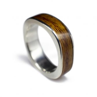 A side view of a square wedding ring made in white gold and canarywood