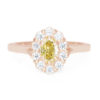 An image of a yellow moissanite engagement ring with a lab-created diamond halo.