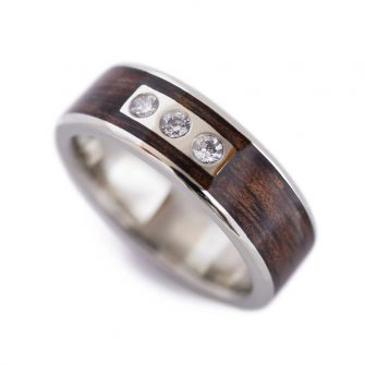A koa wood ring with diamond flush set in gold.