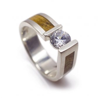 A men's diamond engagement ring with wood.