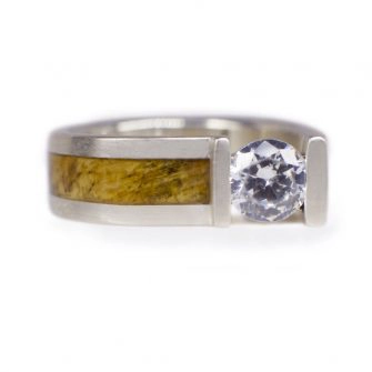 A male engagement ring set with a diamond and wood.